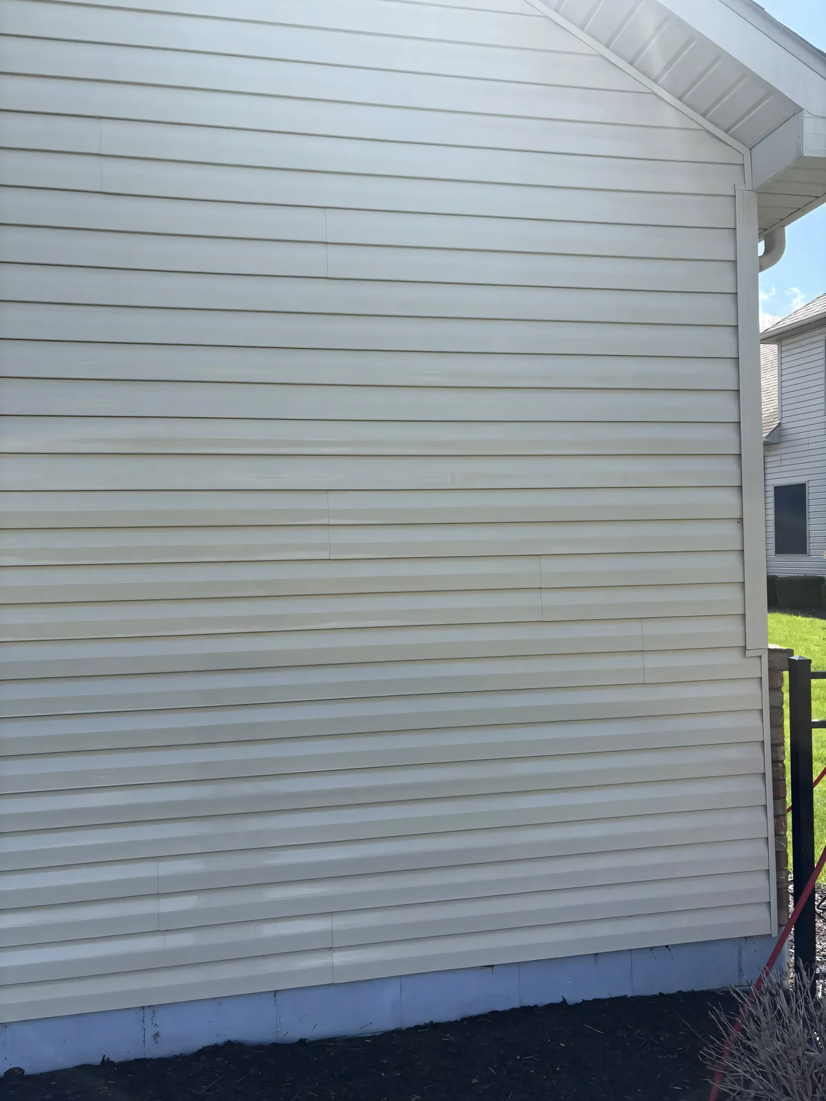 Clean cream siding after soft house wash — mold and mildew cleared