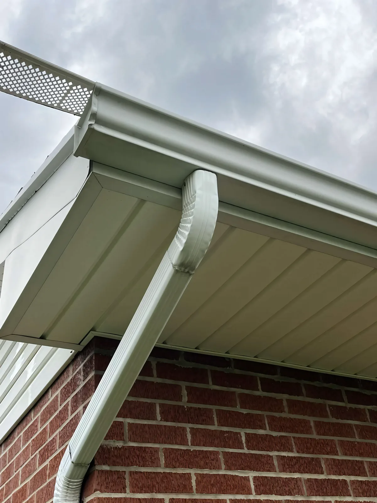 Gutters and soffit cleaned on brick siding — tiger-stripe oxidation removed