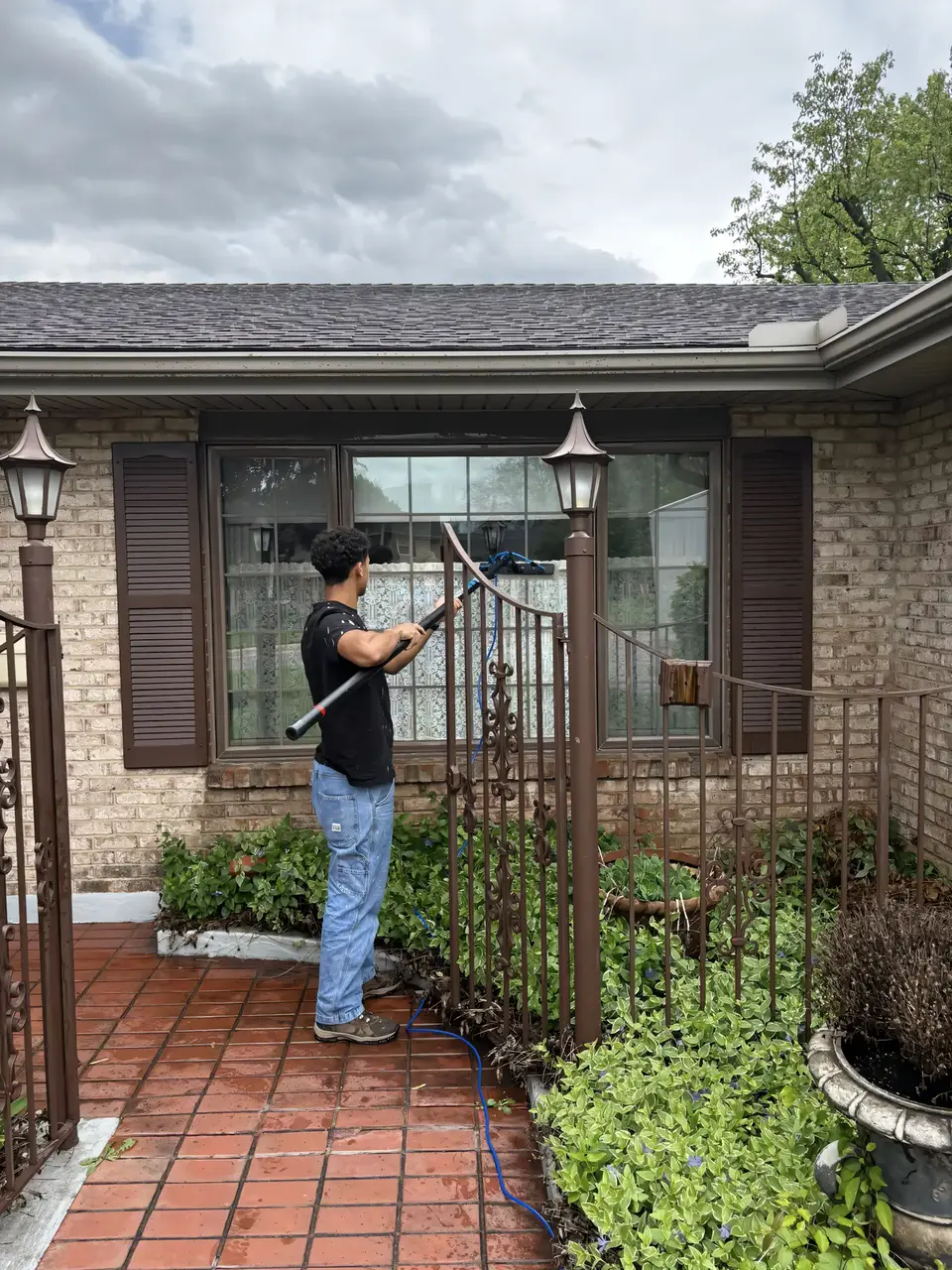 Stoltz tech soft-washing around the windows of a brick home